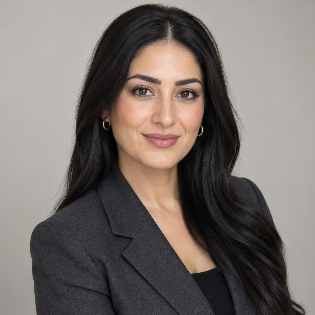 Portrait of a Middle Eastern woman with dark hair in a business outfit